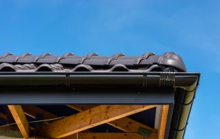 Pitched tiled roof with new black guttering and fascia